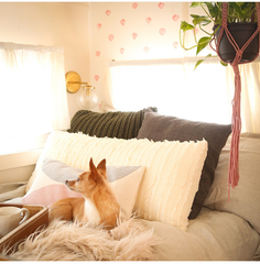 Bedroom decor with mixed textiles and a brass bedside light