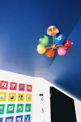 Boys bedroom with blue ceiling and rainbow pictures in the back