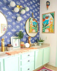 Tropical bathroom design with evil eye blue wallpaper and modern wall sconce