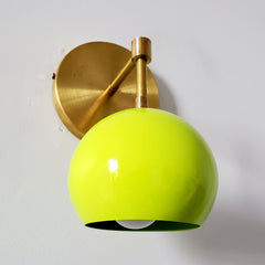 chartreuse green and brass mid century modern inspired wall sconce from a side angle