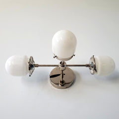 chrome and white three light wall sconce for bathroom vanities