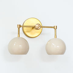 Cream and brass mid century modern two light wall sconce by Sazerac stitches