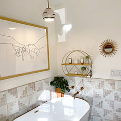 Boho style bathroom with southwest inspired tile, brass plumbing hardware, and modern art