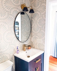 Small bathroom renovation with navy vanity and patterned wallpaper