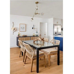 Neutral dining room with black table, rattan chairs, and cane sideboard