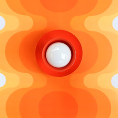 poppy red 70s style ceiling or wall sconce light fixture with retro style orange wallpaper
