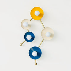 Astrology inspired sconce in mustard, cream, and blue.  Shaped like part of the Gemini star constellation