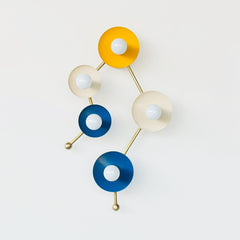 Astrology inspired sconce in mustard, cream, and blue.  Shaped like part of the Gemini star constellation