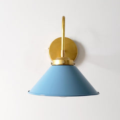 light blue and brass farmhouse modern wall sconce that has a curved brass arm and a light blue cone shade