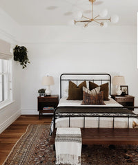 Brass modern chandelier in a neutral bedroom with brown decor