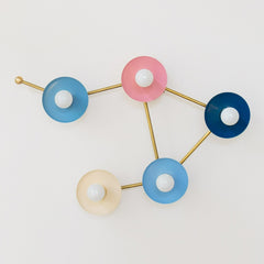 pastel pink blue cream and blue grey wall sconce in the shape of a libra star constellation
