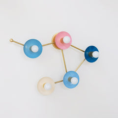 pastel pink blue cream and blue grey wall sconce in the shape of a libra star constellation