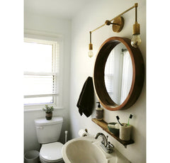 brass sconce over round mirror