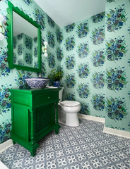 Grandmillenniel preppy modern bathroom decor featuring a green vanity and mirror, mint lighting, and a floral patterned wallpaper