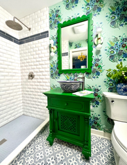 Grandmillenniel preppy modern bathroom decor featuring a green vanity and mirror, mint lighting, and a floral patterned wallpaper