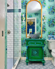 Grandmillenniel preppy modern bathroom decor featuring a green vanity and mirror, mint lighting, and a floral patterned wallpaper