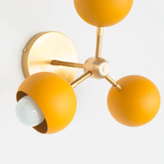 brass and mustard mid century modern wall sconce or flushmount ceiling light made in New Orleans by Sazerac stitches