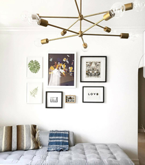 Brass Napoleon Chandelier above a small gallery wall