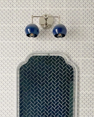 neutral bathroom design featuring grey tile, an acrylic mirror, and natural wood vanity