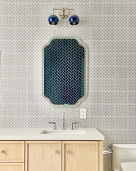 neutral bathroom design featuring grey tile, an acrylic mirror, and natural wood vanity