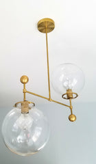 MCM home renovaction large glass globe and brass ball chandelier ceiling fixture raw brass mid century dining room light fixture