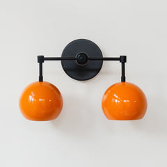 Orange and black mid century modern two light bathroom sconce
