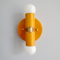 Orange and Brass two light wall sconce or flush mount ceiling light fixture in a bright vibrant color and mid century modern or art deco design