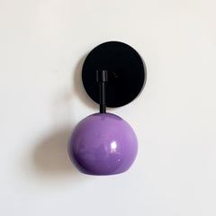 Black and purple midcentury inspired wall sconce with a globe shade