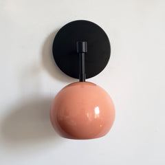Black and peach midcentury inspired wall lighting sconce with globe shade