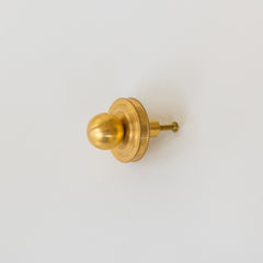 Front and side view of the Phillip Drawer Pull, a round solid brass cabinet knob with a 1-inch ball and detailed beaded backplate, installed on a dark wood drawer. Ideal for traditional, transitional, or vintage-inspired kitchens, dressers, and bathroom vanities. A timeless furniture hardware upgrade handcrafted from solid brass with a warm golden finish.