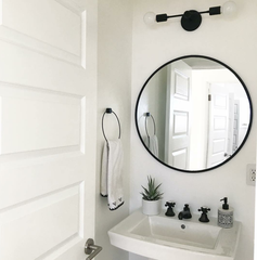 Black modern wall sconce in a farmhouse modern bathroom
