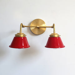 Red and Brass Double Kelly Sconce features colorful shades and a raw brass finish modern bathroom lighting
