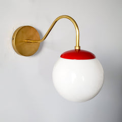 Red and Brass mid century modern inspired wall sconce with a globe shade