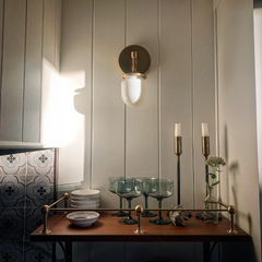 small brass sconce over a bar cart