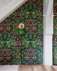 Green mid cntury modern wall sconce on a botanical style wallpaper in a vintage pattern