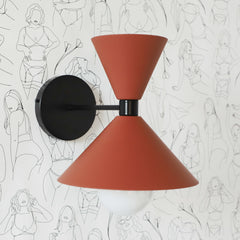 black and terra cotta Mid century modern wall sconce on neutral wallpaper