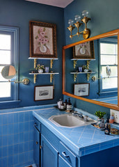 vintage blue tile bathroom with brass and wood accents