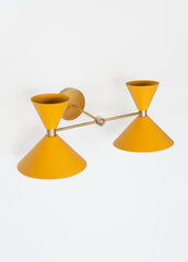 brass and mustard yellow mid century modern wall sconce with two shades.  Colorful bathroom light fixture