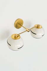 boho-inspired handmade wall sconce with speckled shades, black lines, and more.