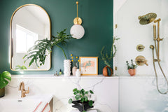 Pink and Brass Wall Sconce in modern green and marble bathroom renovation