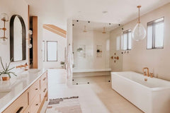 Neutral modern bathroom with freestanding tub, sconces by Sazerac Stitches