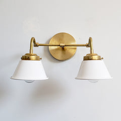 White and Brass Double Kelly Sconce features colorful shades and a raw brass finish modern bathroom lighting