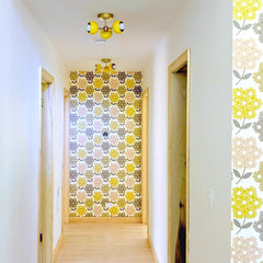 Yellow and brass mid century modern flushmount ceiling light in a retro style hallway