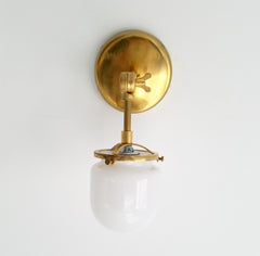 single articulating brass library sconce with glass