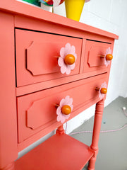 pastel pink and orange daisy drawer pull on a coral nightstand