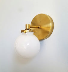 brass and white wall sconce globe shade lighting design