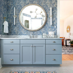 Grey blue bathroom with modern sconces and a branched chandelier