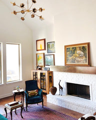 Eclectic living room with thrifted and antique furniture, floral chandelier, and neutral walls