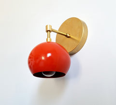 midcentury modern inspired wall sconce in orange and brass