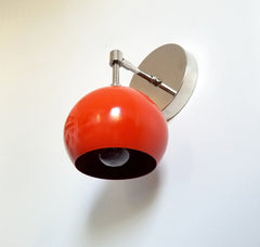 modern wall sconce midcentury inspired in chrome with orange eyeball shade